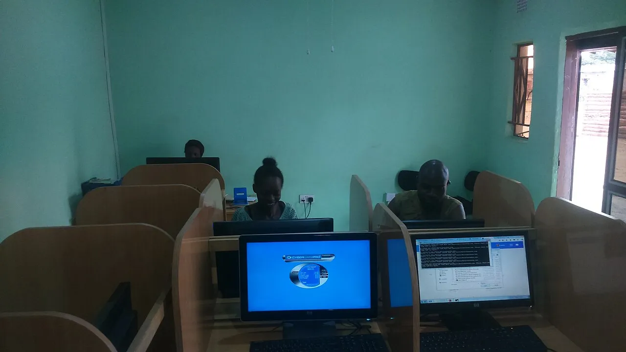 An internet café in Zambia, managed by a local attendant at a row of desktop computers.