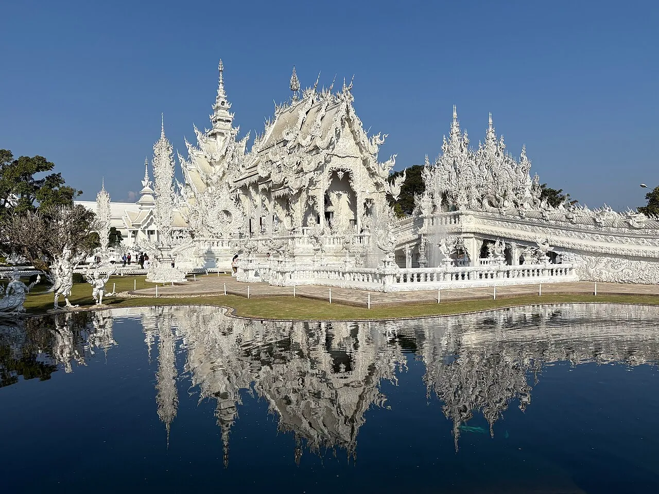 Wat Rong Khun, the White Temple, with its ornate white and silver-mirrored facade in Chiang Rai, Thailand.