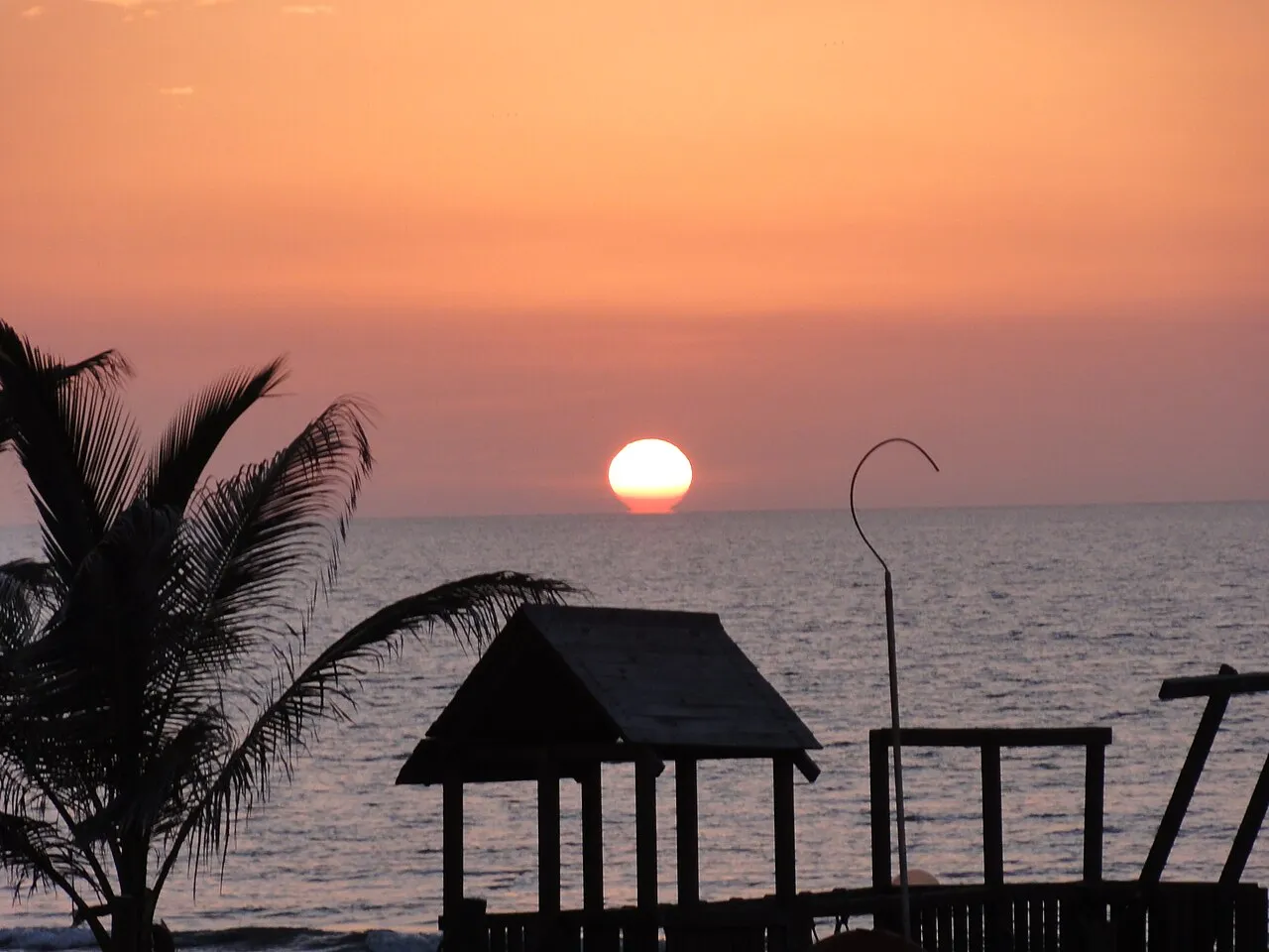 Sunset over the beach and palm trees at Brufut Beach on the Gambian coast.