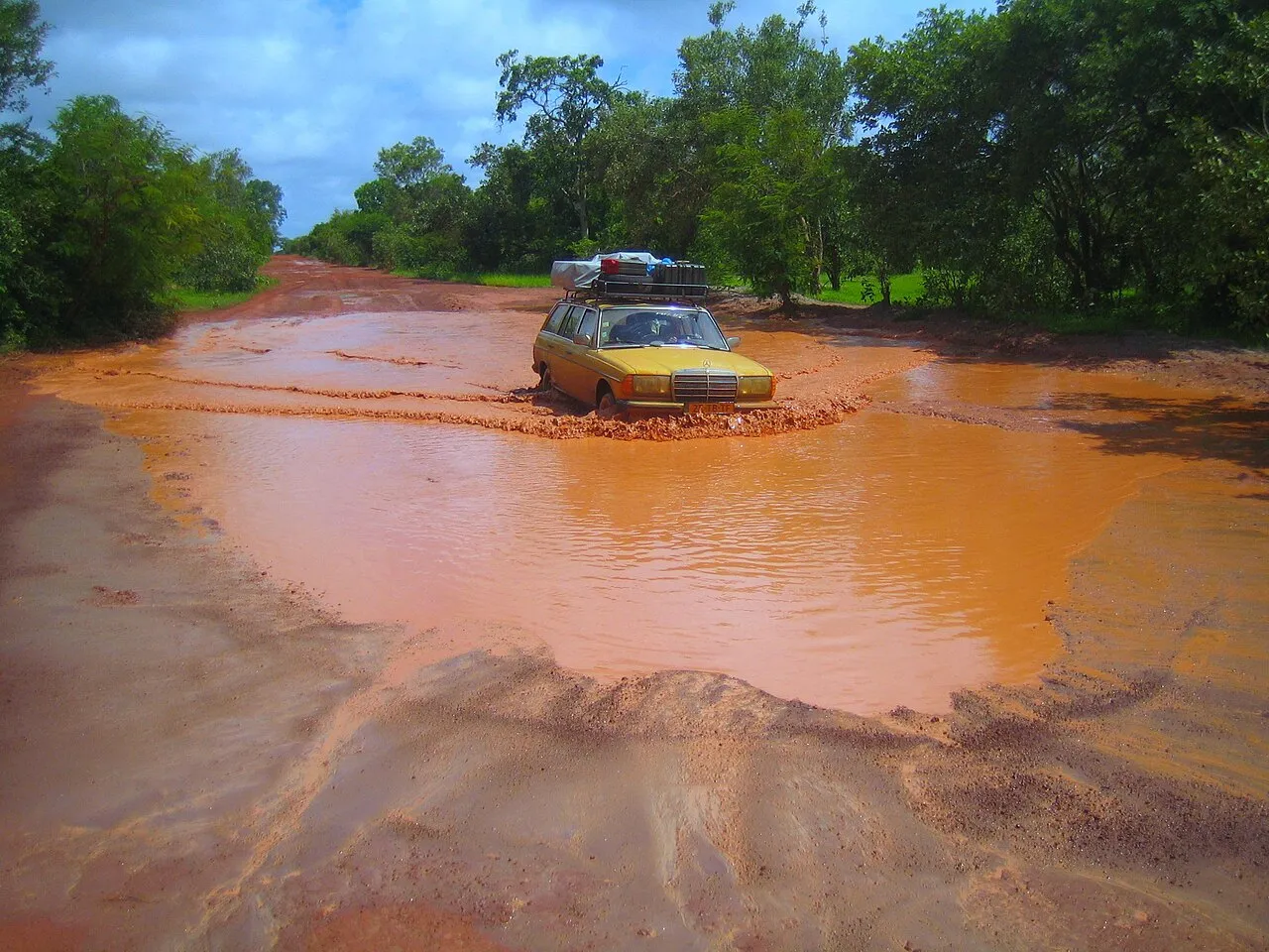 A car on a flooded road in the Gambia during the rainy season.
