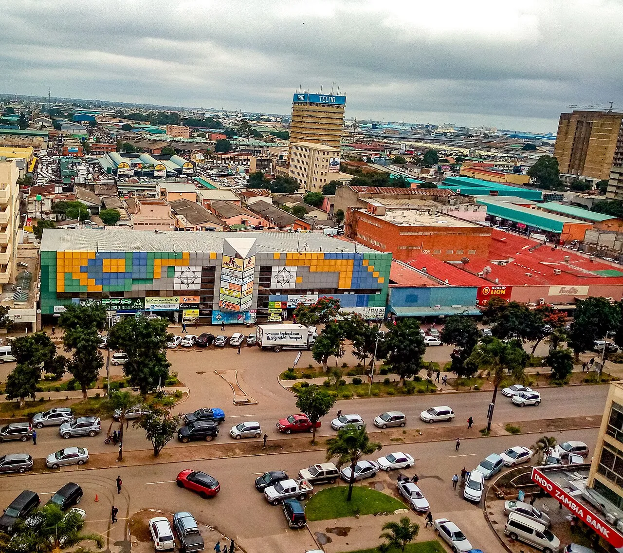 A street view of Cairo Road, Lusaka's main commercial thoroughfare, with minibuses and pedestrians in the city centre.