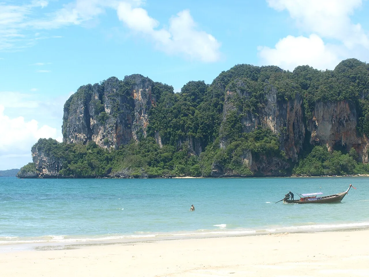 Railay Beach's limestone cliffs rising above the sand and turquoise water of the peninsula.