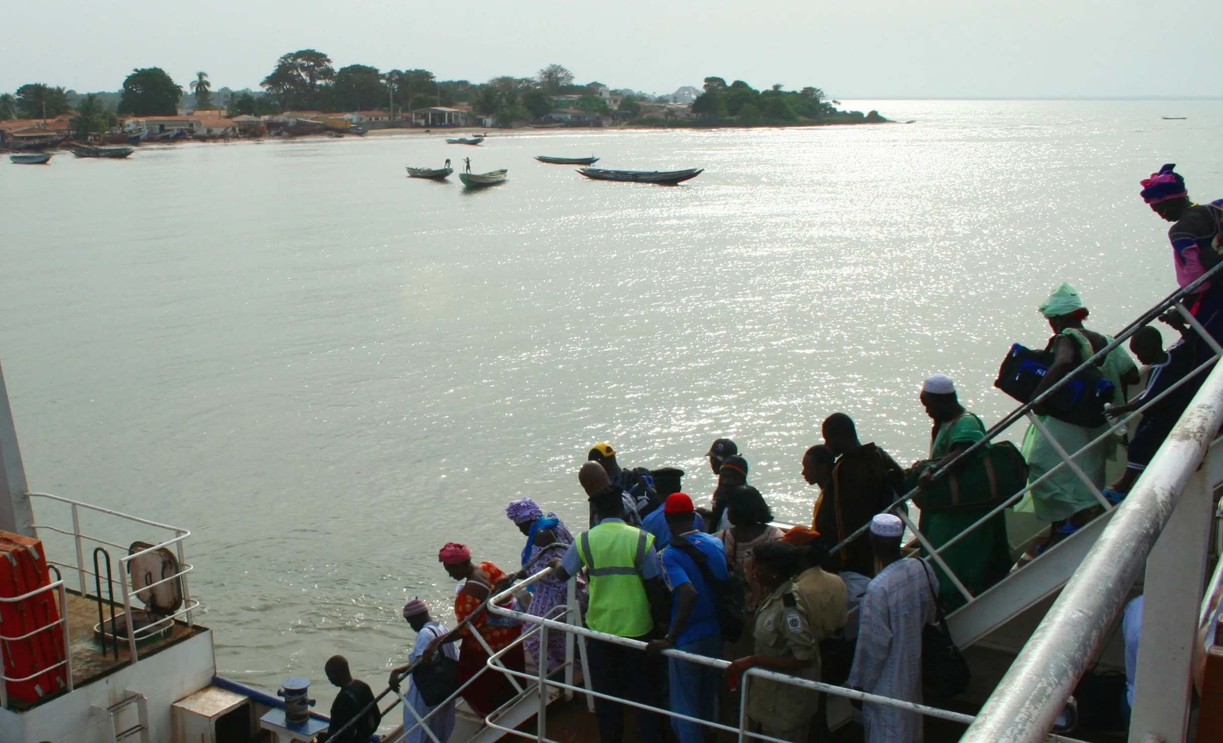 Passengers on the deck of the Banjul-Barra ferry approaching the north bank of the River Gambia.