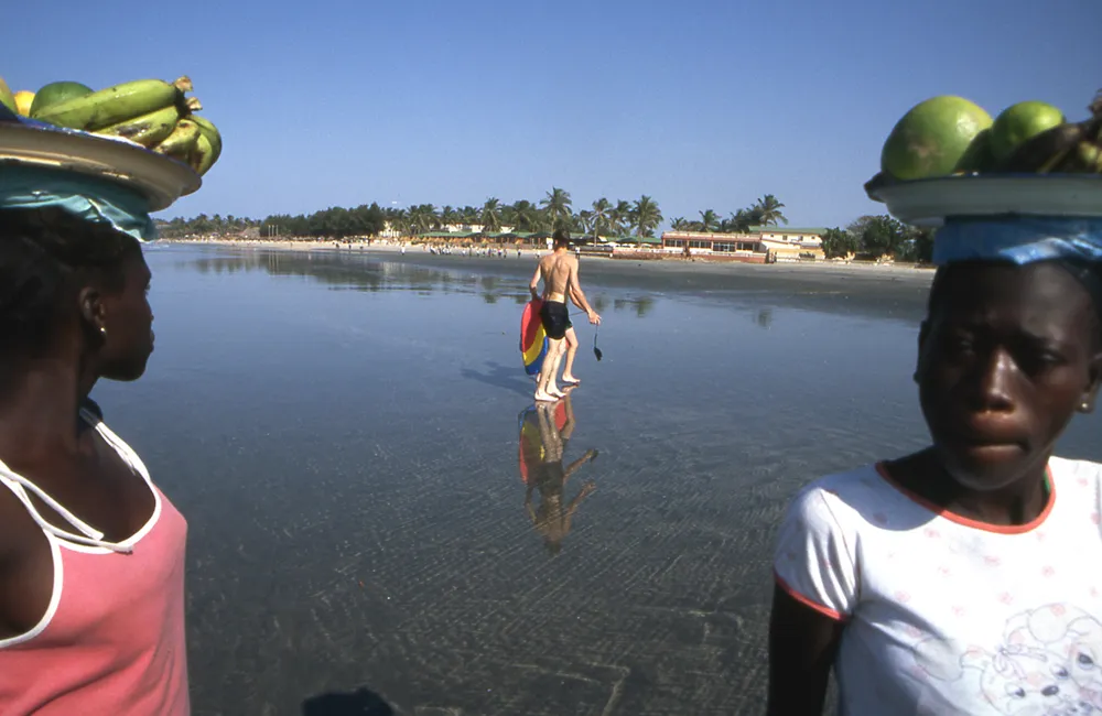 Girls selling fruit on the Atlantic Ocean beach at Kotu, the Gambia.