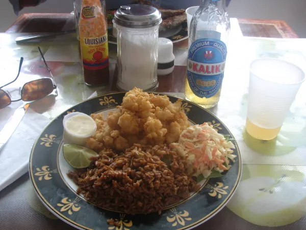A plate of cracked conch with peas and rice and coleslaw, a classic Bahamian meal, served at a restaurant in Grand Bahama.