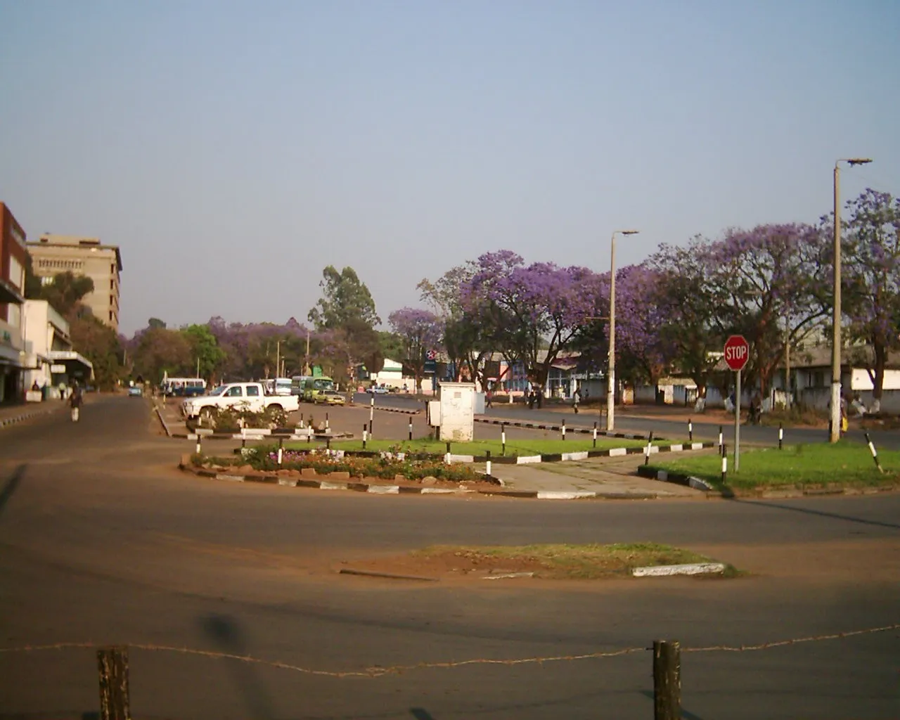 A street scene in Ndola, Zambia, with roadside shops and passers-by in the Copperbelt town centre.