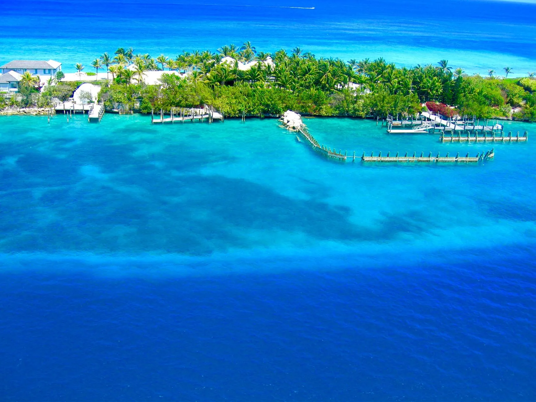 Aerial view of Nassau and its turquoise harbour waters, with green islands and jetties along the shore.