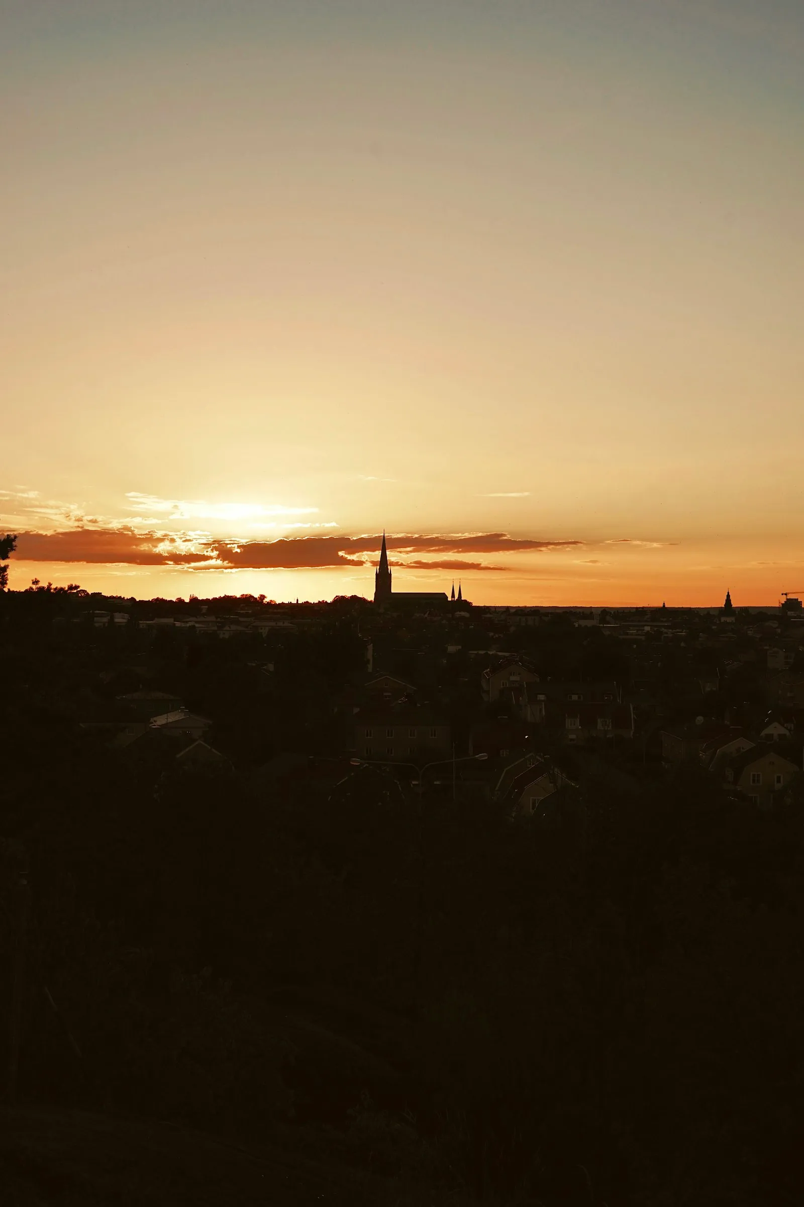 Sunset over Linköping with the cathedral spire in silhouette above the rooftops