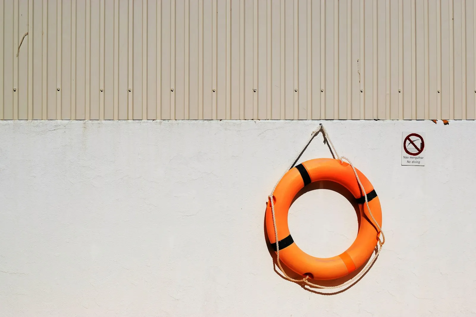 A round orange-and-white life buoy hanging on a wall