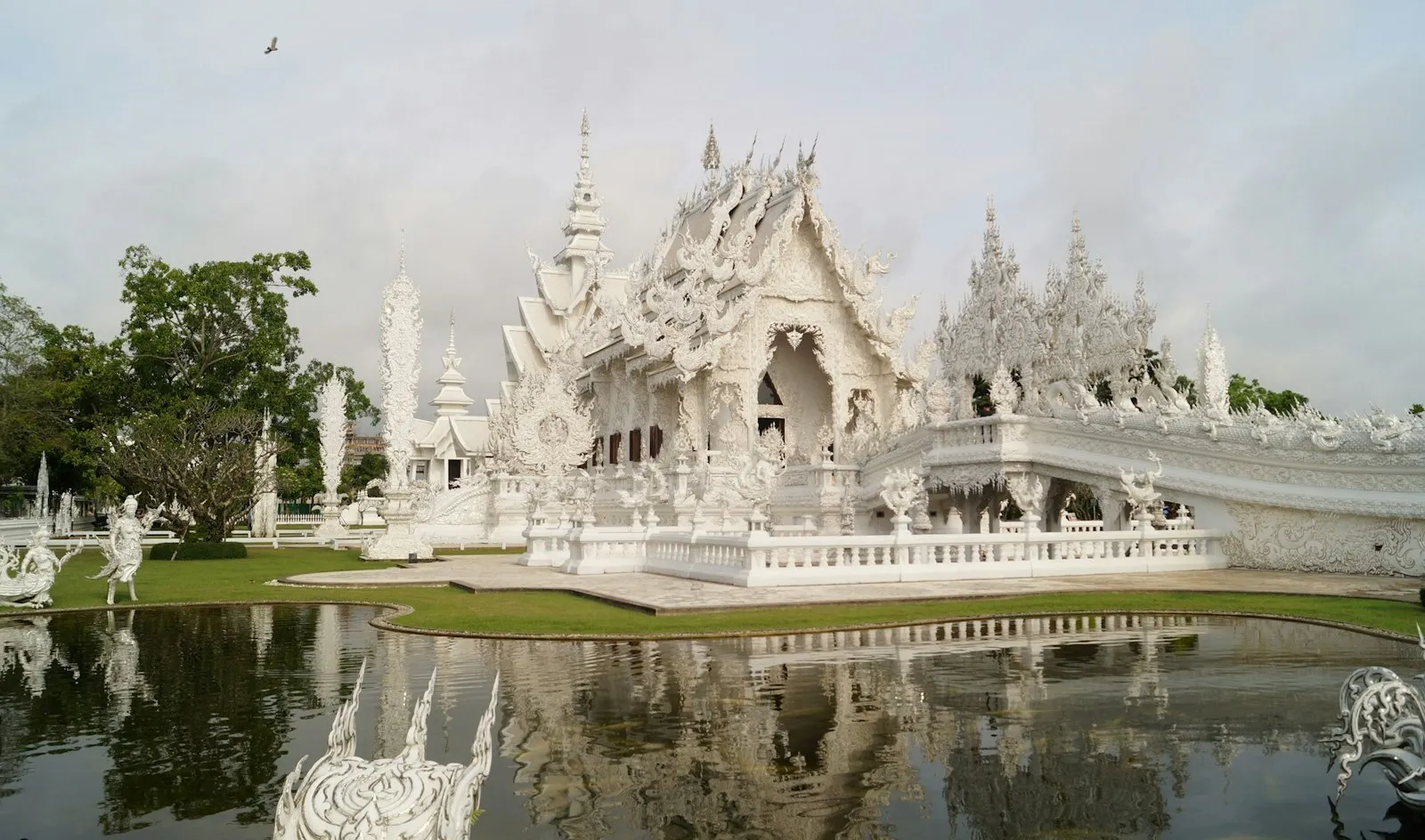 The white, mirror-studded spires of Wat Rong Khun rising against a bright sky near Chiang Rai