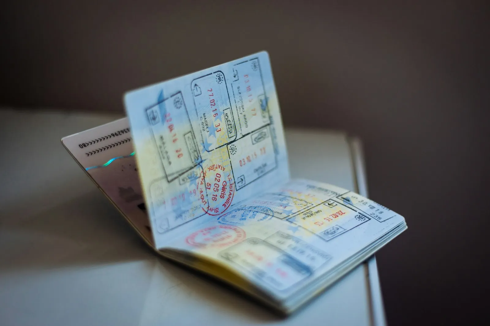 An open passport standing on a table, its pages full of entry and exit stamps